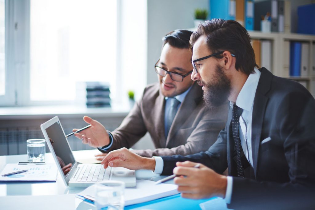 two employees discussing electronic data at meeting